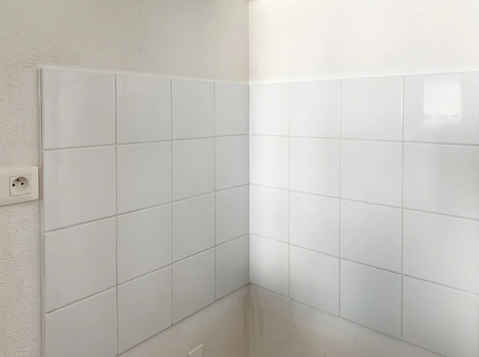 Coin de salle de bain avec carrelage mural blanc brillant, format rectangulaire en pose décalée