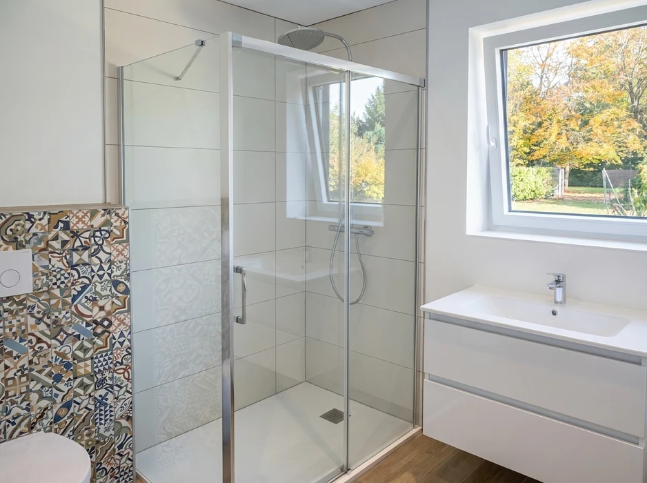 Salle de bains moderne avec douche à l'italienne, cabine en verre trempé à cadre aluminium chromé, receveur extra-plat